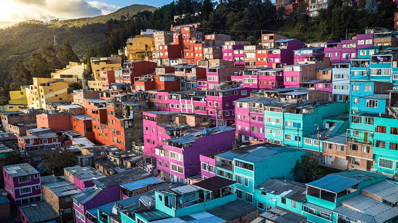 A view of a dense, hillside city at sunset