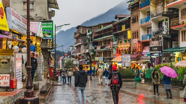 Pedestrians walking on a sidewalk in an Indian city