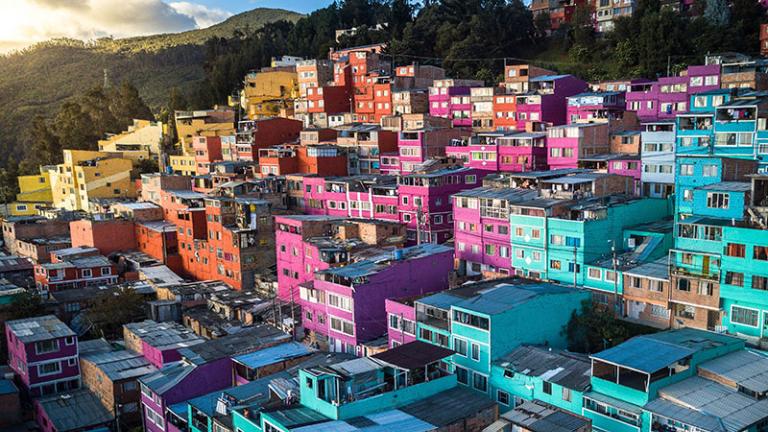 A view of a dense, hillside city at sunset